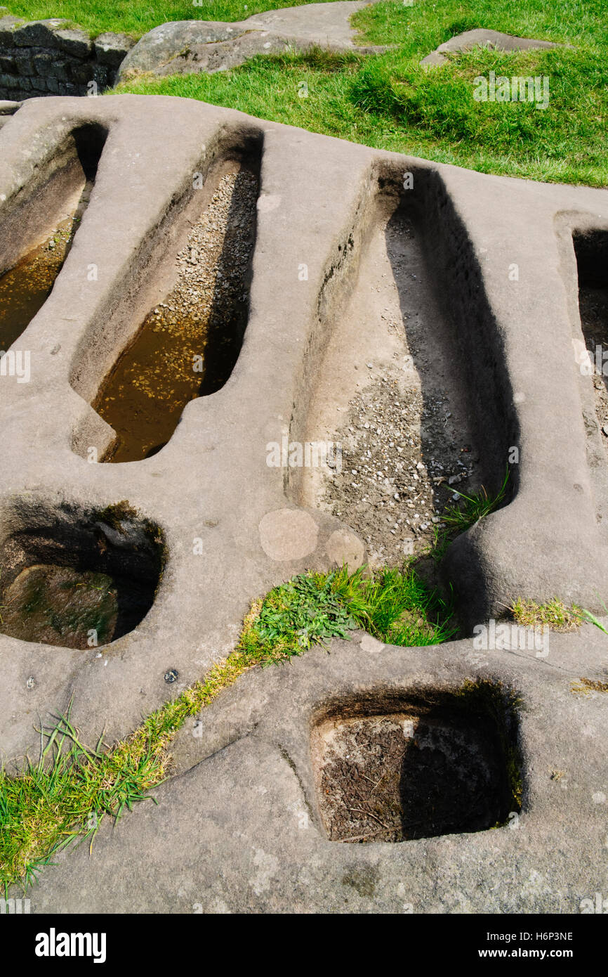 Two of six body-shaped graves & two cross-sockets cut in a sandstone outcrop adjacent to St Patrick's C8th Anglo-Saxon chapel on Heysham Barrows. Stock Photo