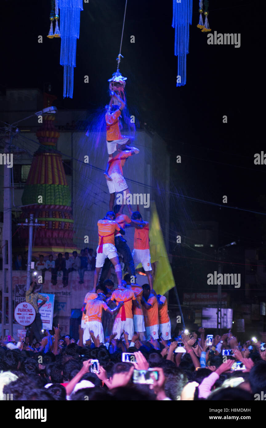 Human pyramid broken dahi handi shower of curd and turmeric water on janmashtami festival, Pune Stock Photo