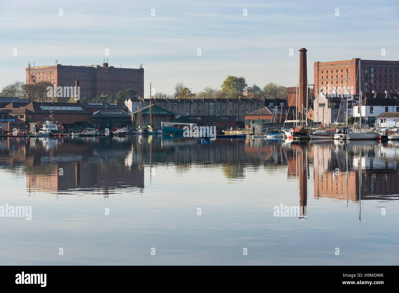 The historic Underfall Yard on Bristol's Floating Harbour, with a red brick chimney and warehouses behind. Stock Photo