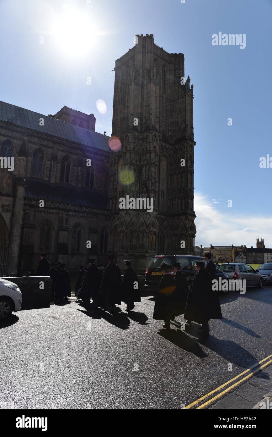 Choristers from Wells Cathedral Choir  in cloaks walking  to evensong at the Cathedral on Easter Day against the sun. Stock Photo