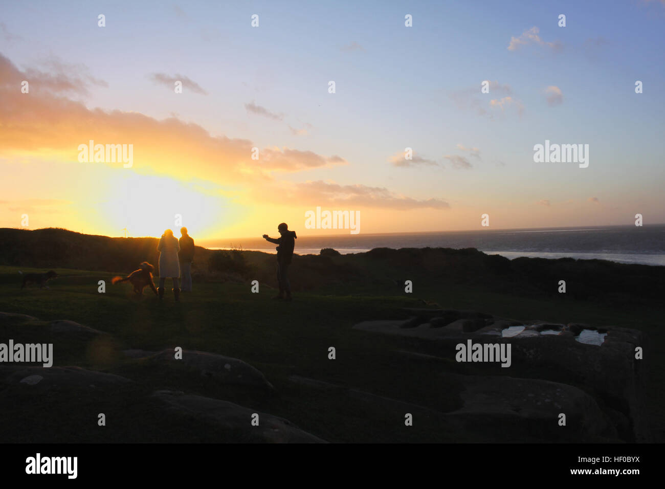 Heysham Barrows, Heysham , Lancashire, UK. 26th December 2016. UK Weather:   Sunsets over Irish Sea from St Patrick's Chapel on Heysham Barrows over the Graves which featured on the cover of the Best of Black Sabbath Credit: David Billinge/Alamy Live News Stock Photo