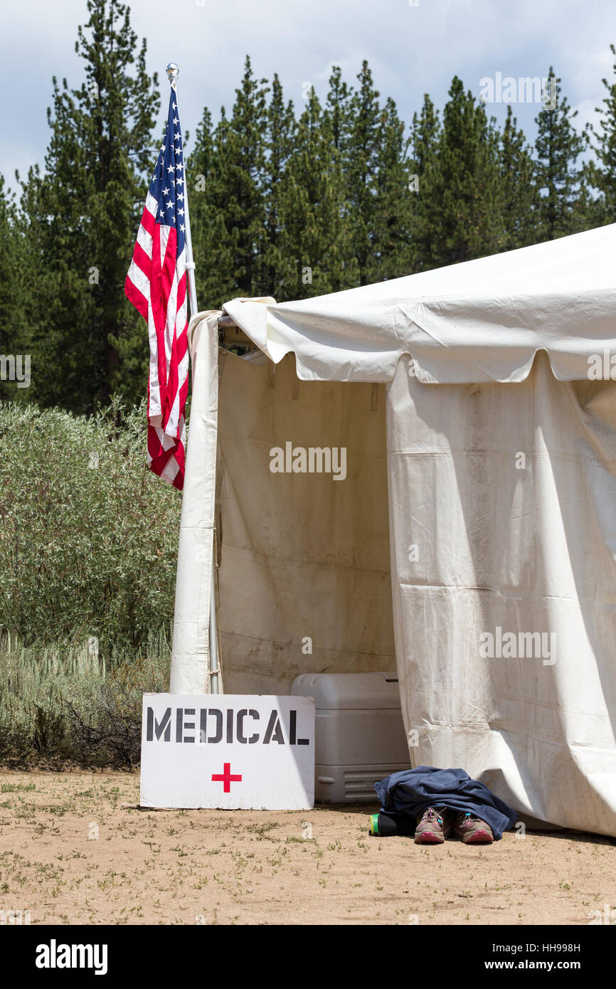 Medical tent entrance with a hand-made medical sign and an American Flag.  Runners aid station with shoes outside entrance. Stock Photo