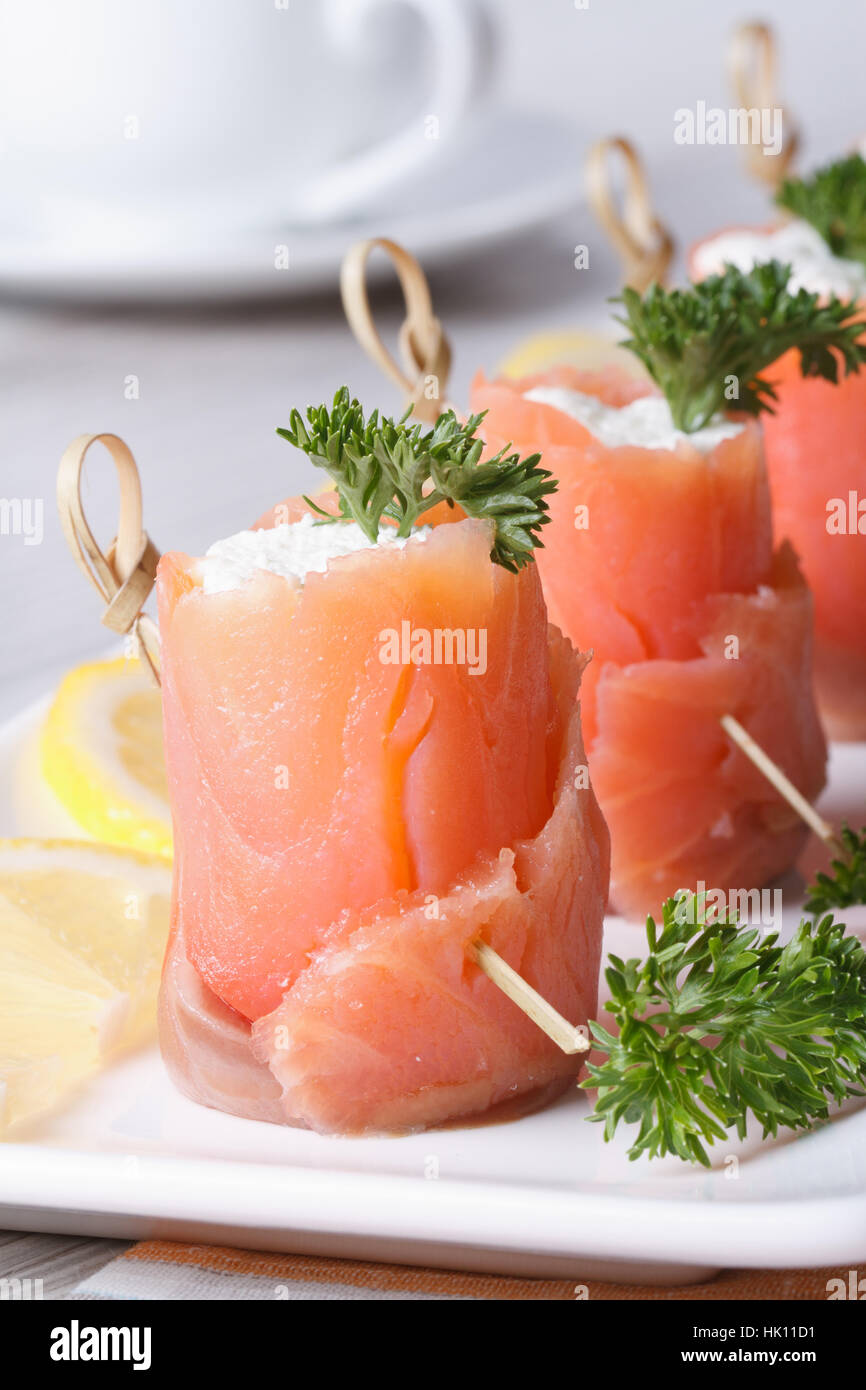 Banquet. Rolls of red fish with cream cheese close-up on the table vertical Stock Photo