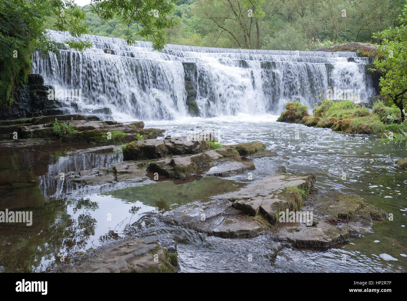 Derbyshire, UK - July 20 2014 - Man made waterfall Monsal Dale weir on the River Wye, Monsal Dale, Derbyshire, Peak District UK Stock Photo