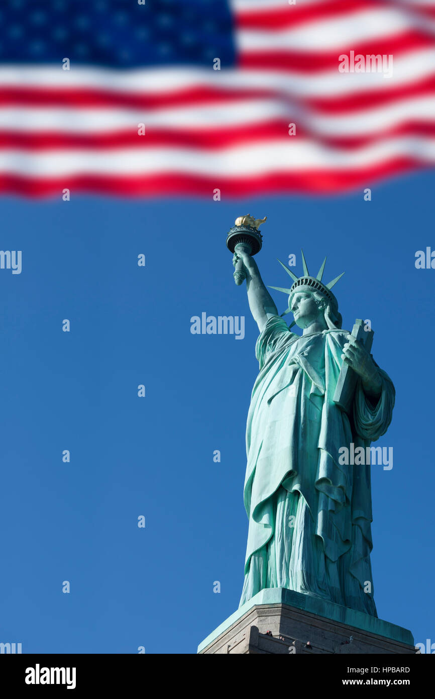 The Statue of  Liberty and the US flag, New York city, New York. USA Stock Photo