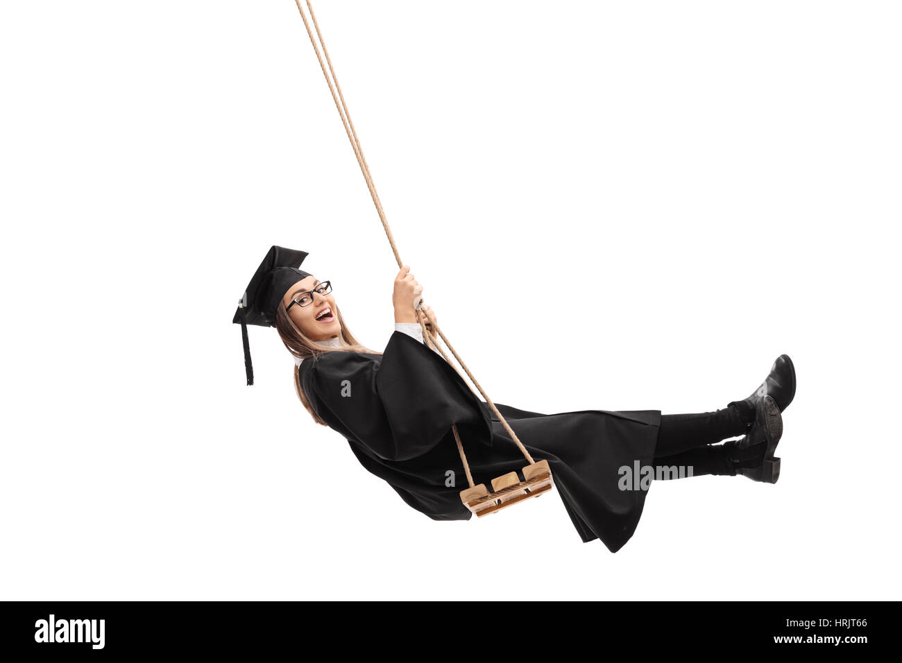 Joyful graduate student swinging on a swing Stock Photo