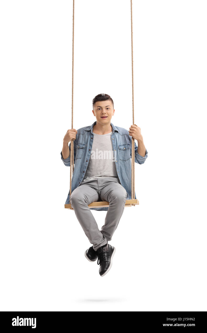 Teenage boy sitting on a wooden swing and looking at the camera isolated on white background Stock Photo