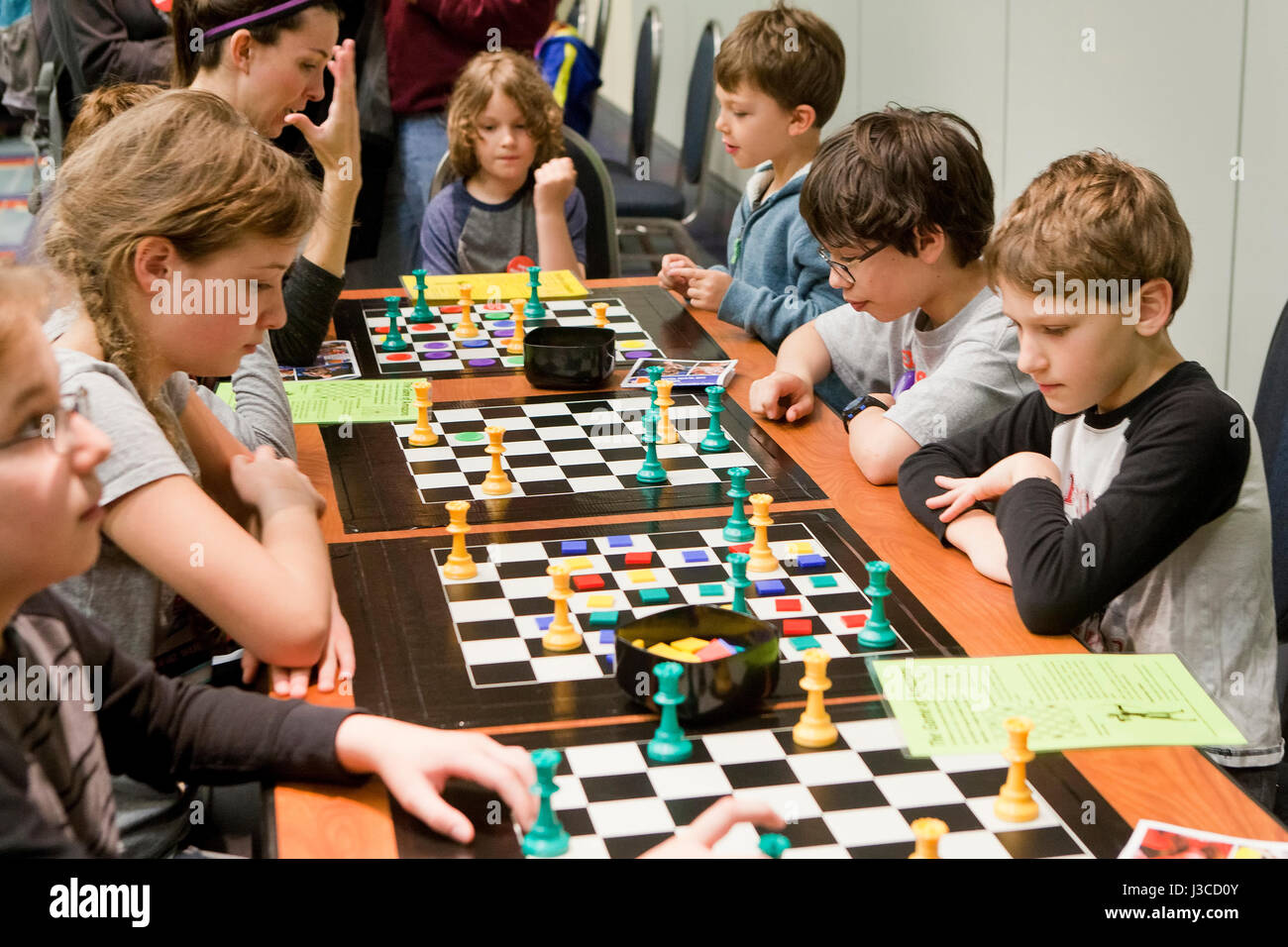 Caucasian American school children playing Game of the Amazons board game - USA Stock Photo