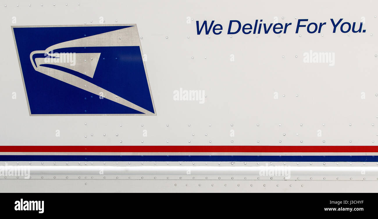 Closeup of a side of a USPS truck with the service's logo and motto. Stock Photo