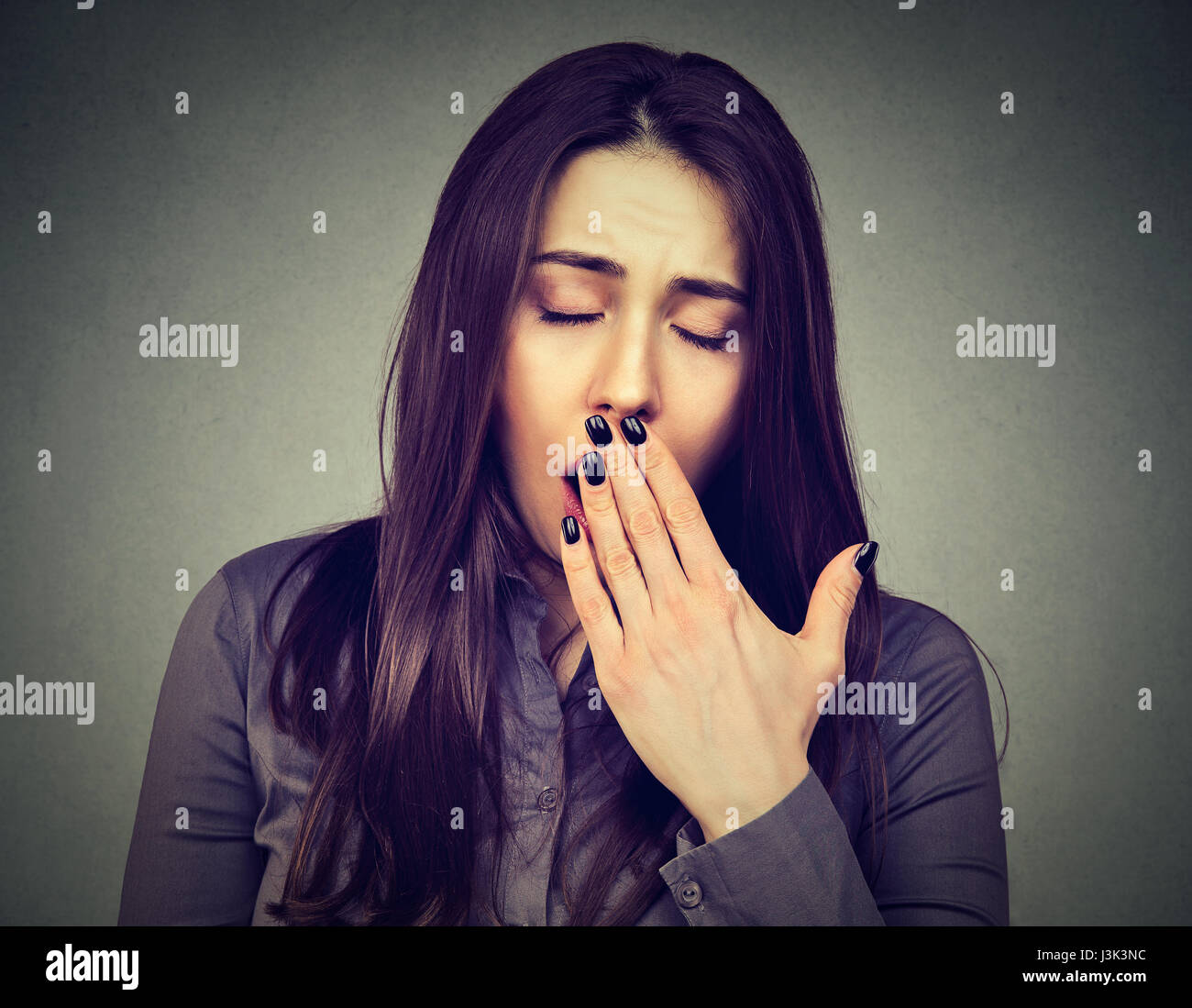 sleepy woman yawning eyes closed looking bored Stock Photo