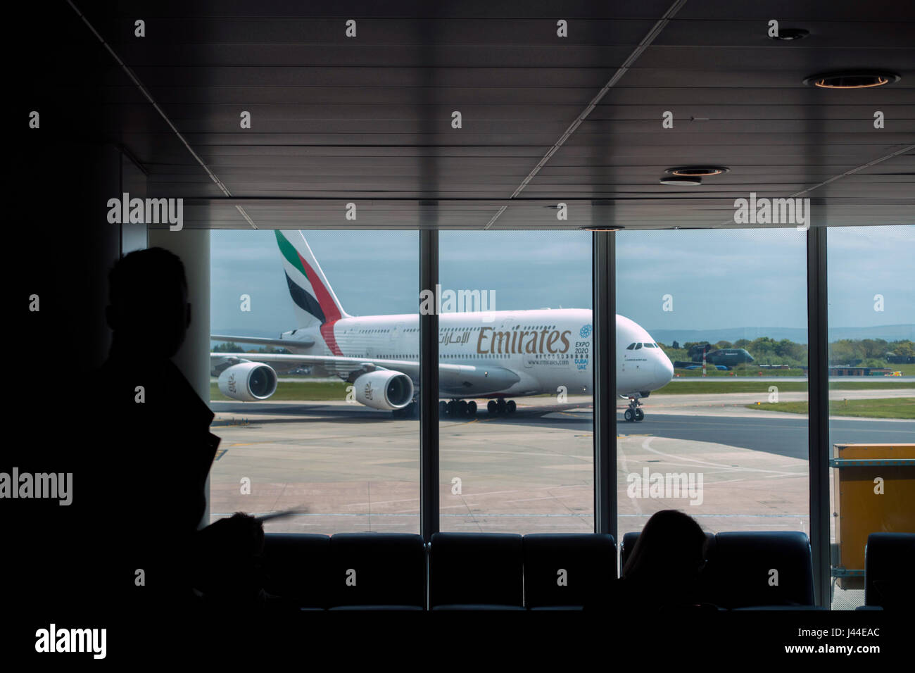 Emirates Airbus A380 arriving at Manchester airport seen through lounge window Stock Photo