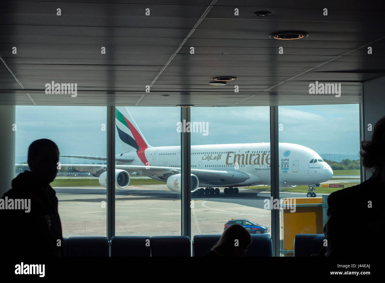 Emirates Airbus A380 arriving at Manchester airport seen through lounge window Stock Photo