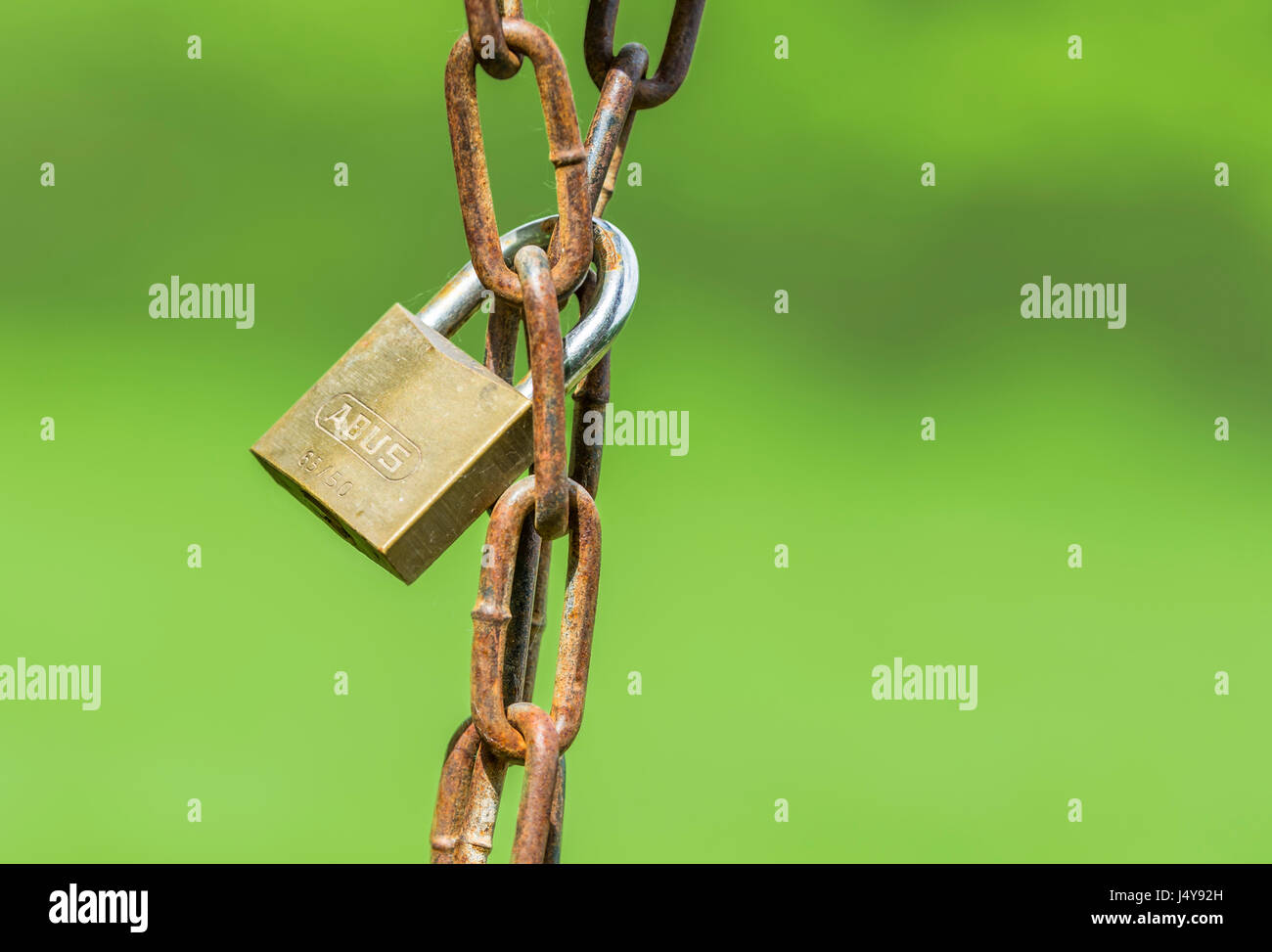 Locked concept. Locked padlock around a rusty chain. Lock hanging from a chain. Stock Photo