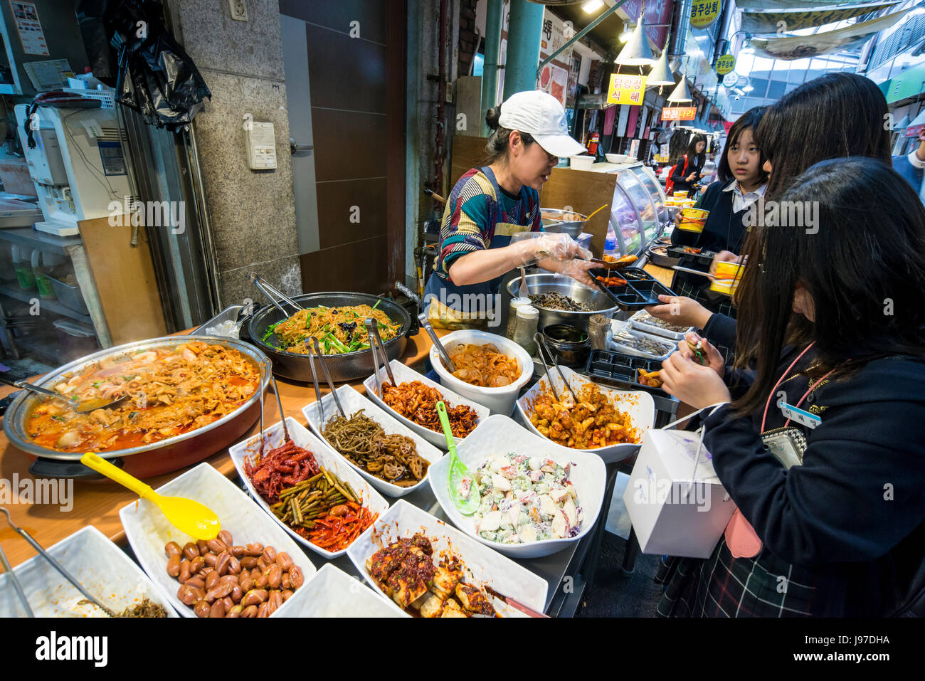 The vendor serving customers at a food stall in Tongin Market, Tongin dong, Seoul, South Korea Stock Photo