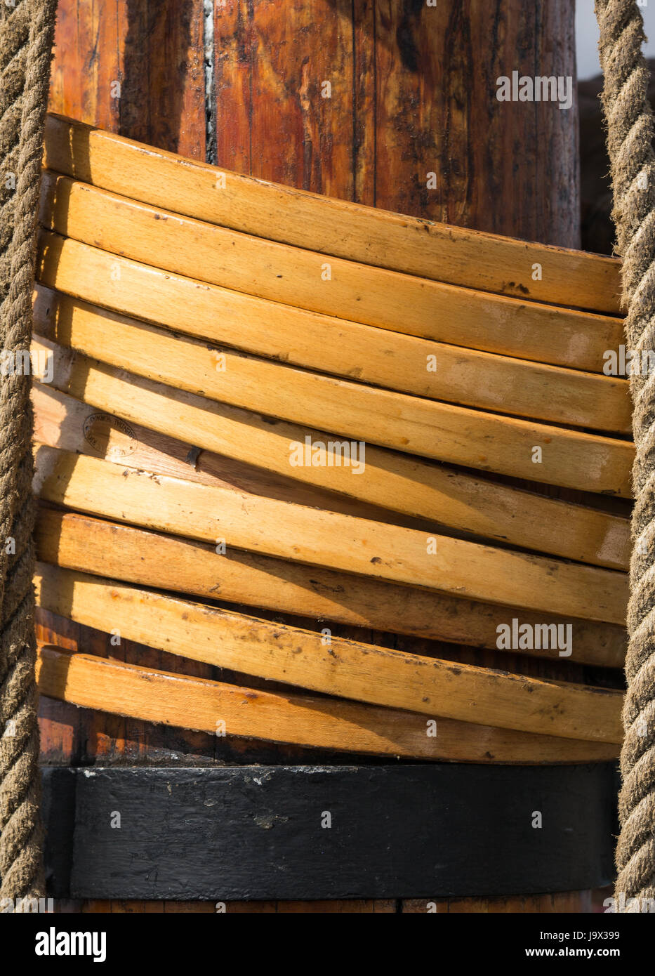 Detail of the mainmast on an old sailing ship showing circular wooden hoops attached to the mainsail Stock Photo