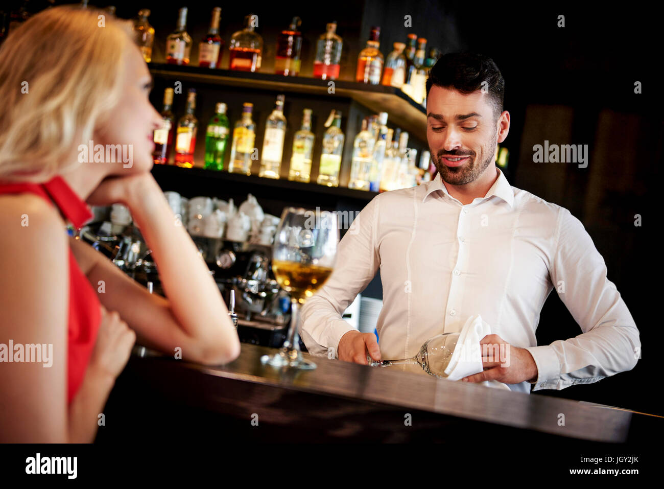 Barman flirting with young woman sitting at bar Stock Photo