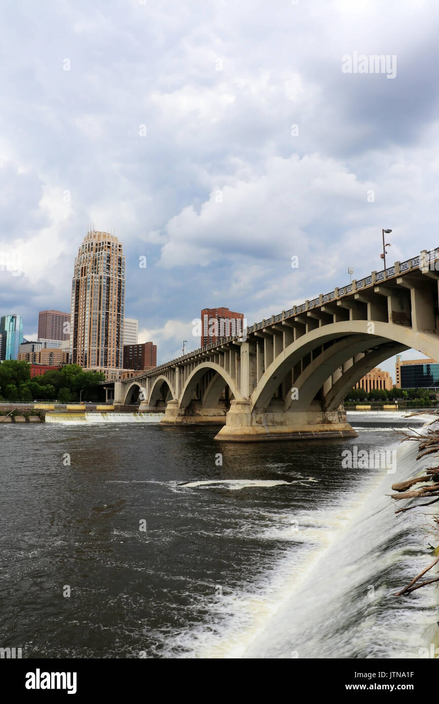 Minneapolis downtown skyline and Third Avenue Bridge above Saint Anthony Falls and Mississippi river, Midwest USA, state of Minnesota. Vertical compos Stock Photo