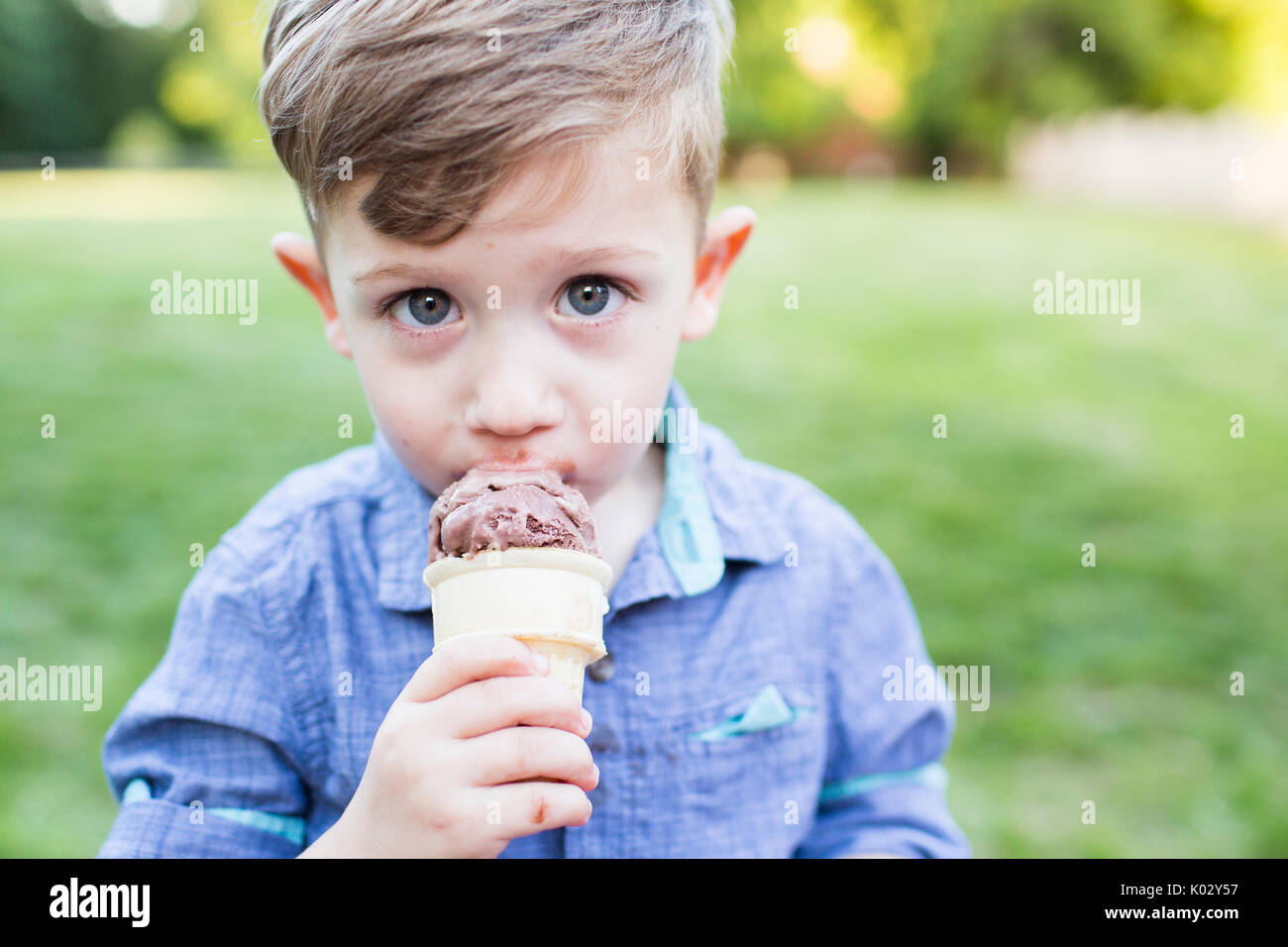 Portrait cute preschool boy eating ice cream cone Stock Photo