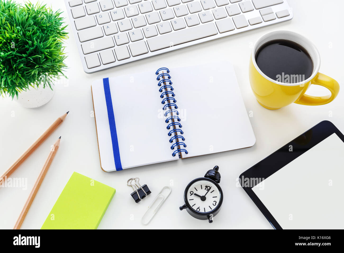 Modern office desk with computer blank notebook clock and coffee cup ...