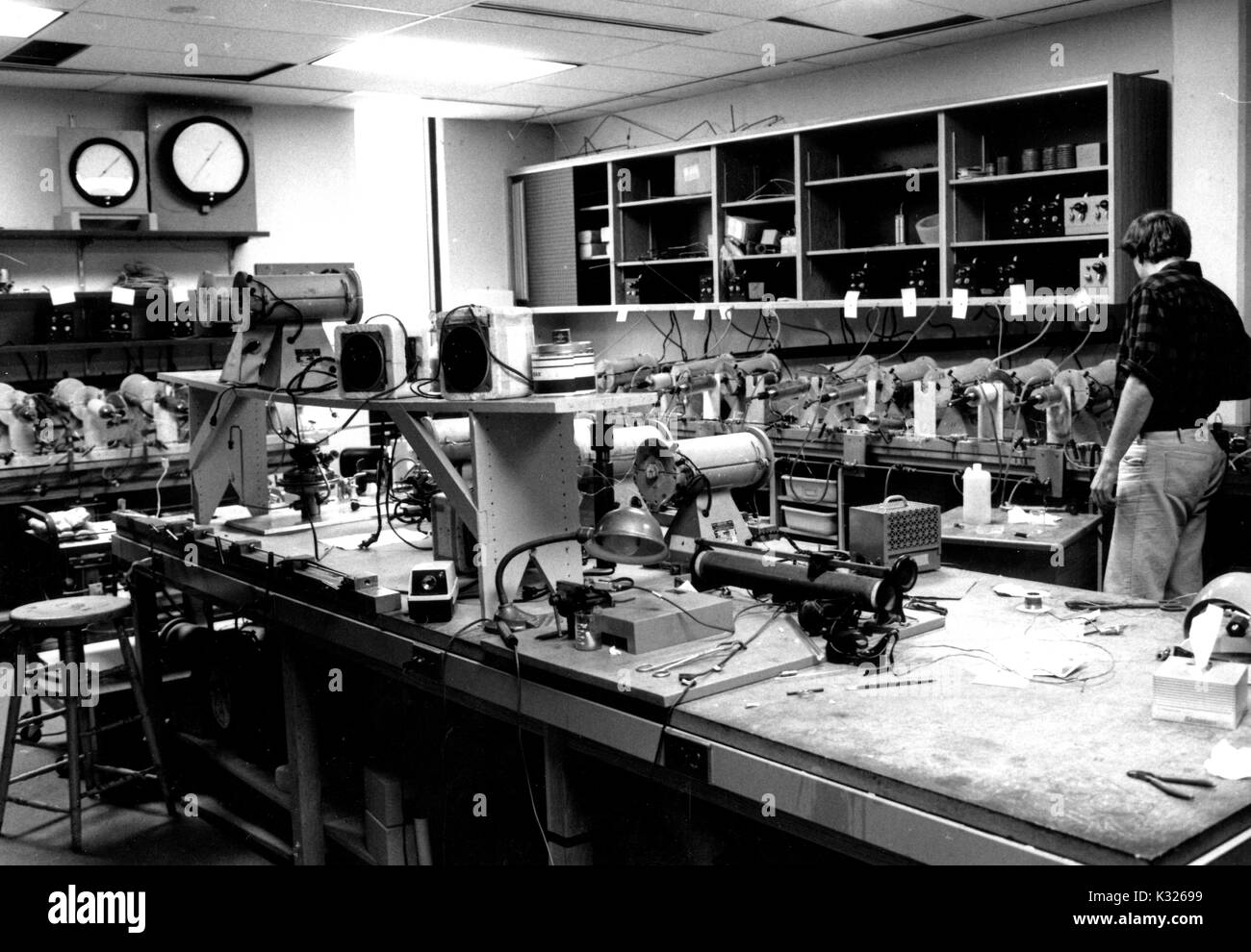 Inside the Experimental Petrology Laboratory inside Olin Hall -- the Earth and Planetary Science building at Johns Hopkins University -- Hans Eugster, an internationally known geochemist and long time professor of geology at Johns Hopkins, works alone in a room full of equipment and wires, Baltimore, Maryland, 1986. Stock Photo