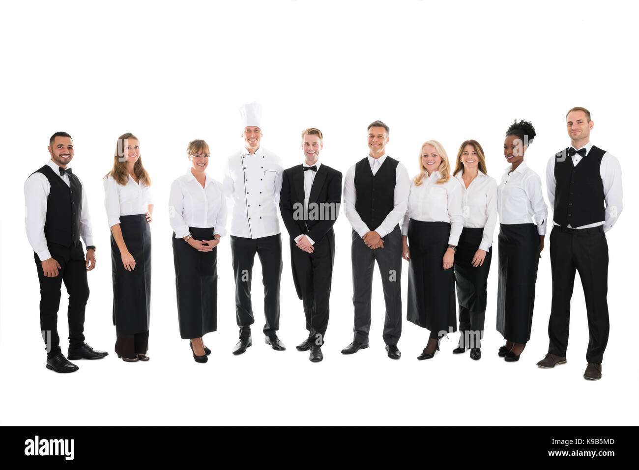 Full length portrait of confident restaurant staff standing in row against white background Stock Photo