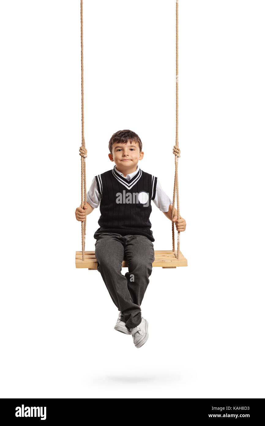 Small schoolboy seated on a wooden swing isolated on white background Stock Photo