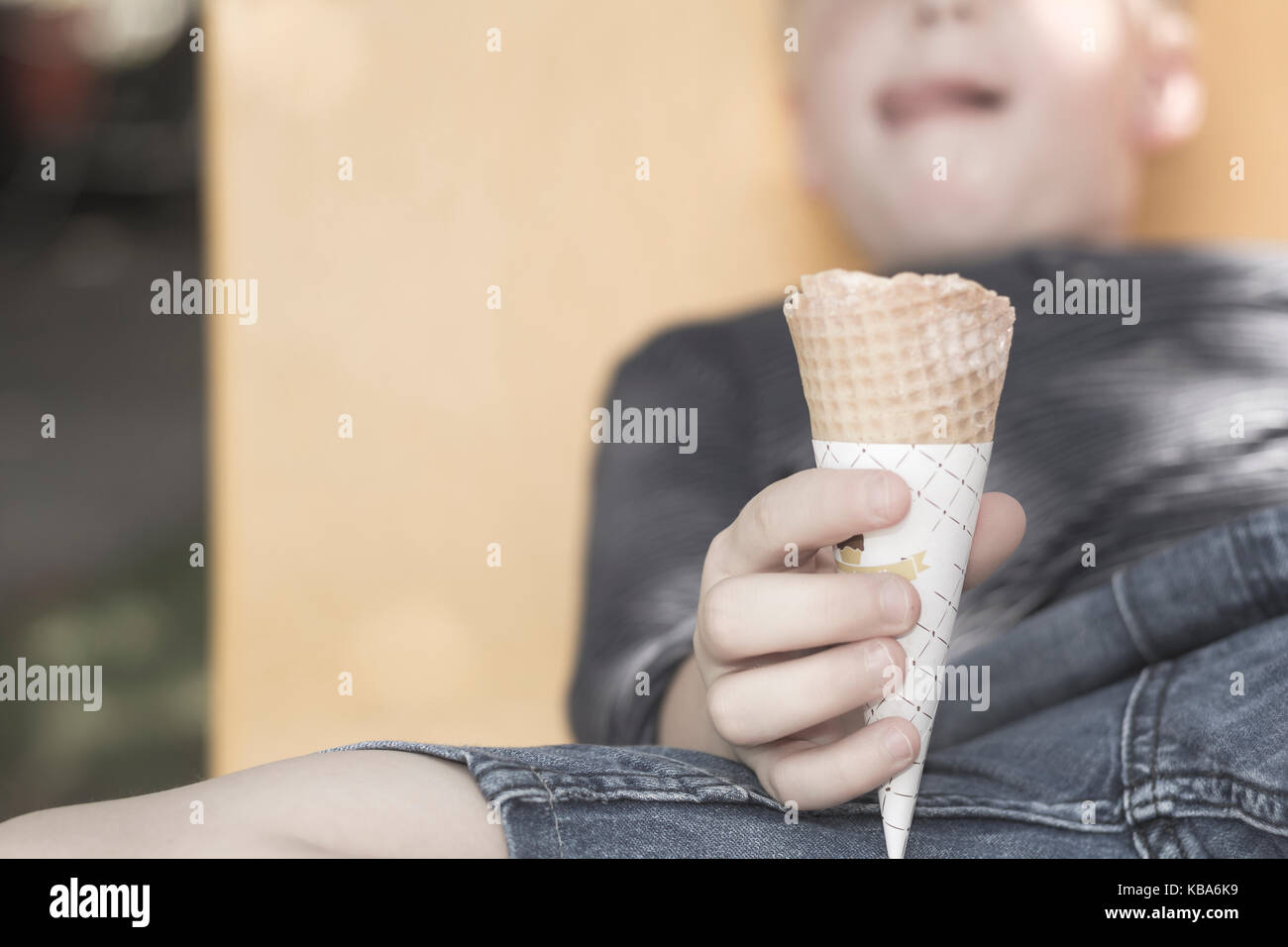 a boy is holding ice cream cone, blurred background Stock Photo