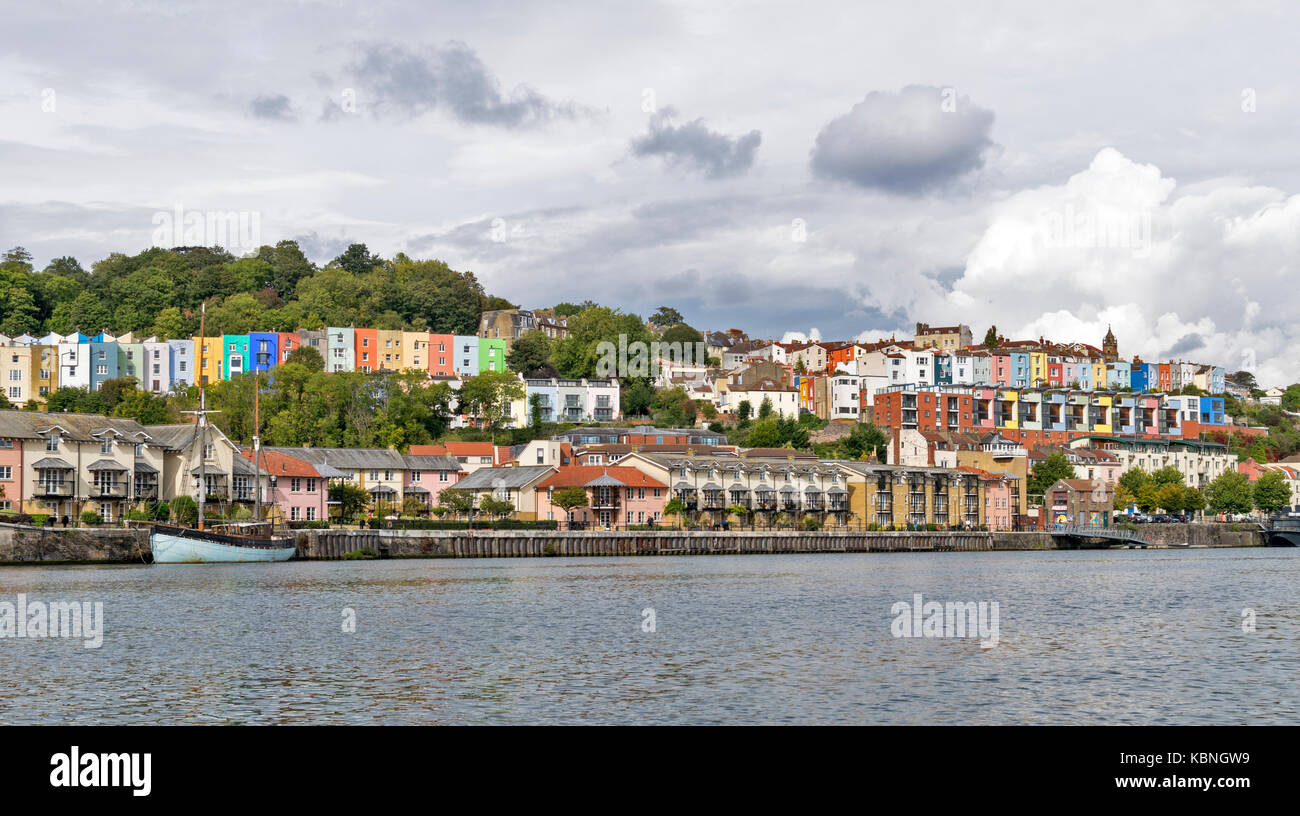 BRISTOL ENGLAND CITY CENTRE HARBOURSIDE HOTWELLS RIVER AVON ROWS OF COLOURED HOUSES ALONGSIDE THE HARBOUR AND TREE LINED  HILL Stock Photo