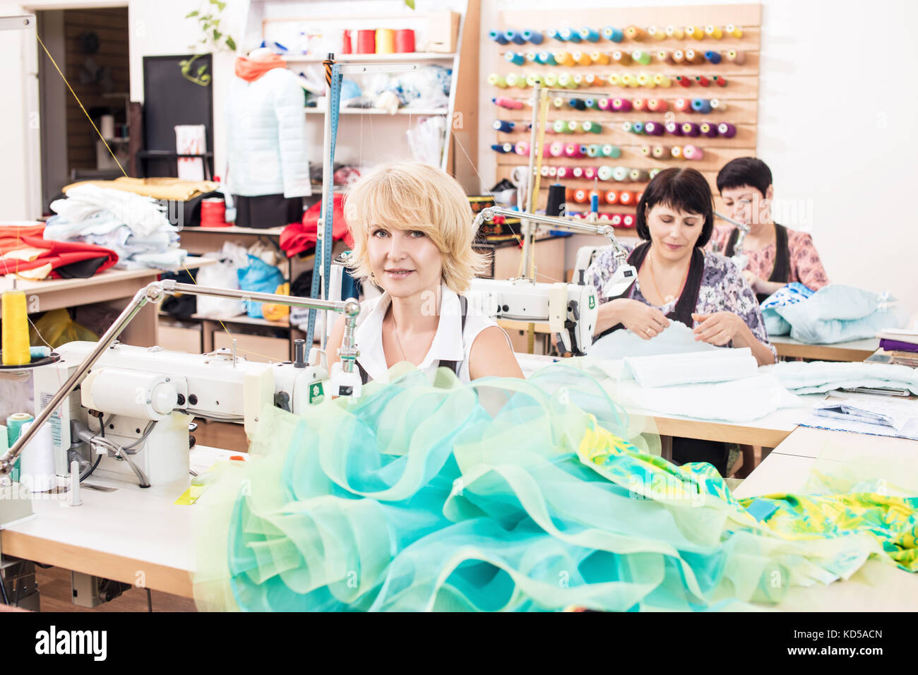 Seamstresses sews dresses in atelier studio. Stock Photo