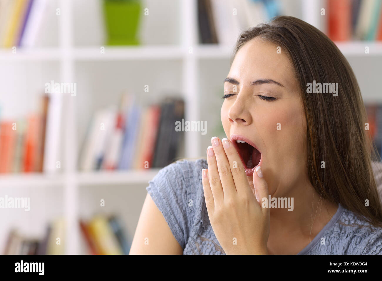 Tired lady yawning in a house interior Stock Photo