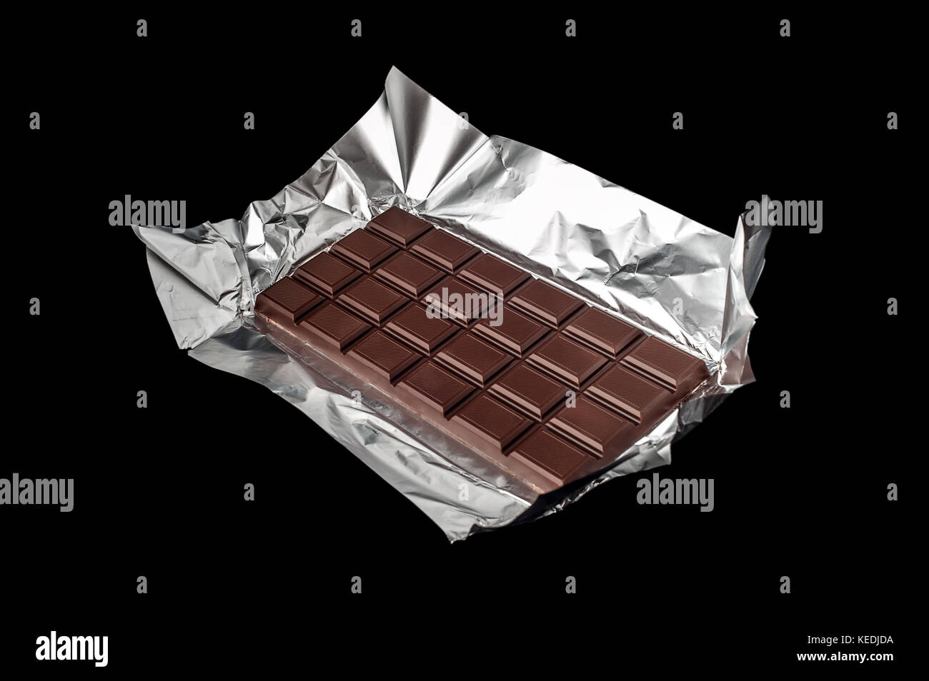 Chocolate bar in wrapper isolated on black background Stock Photo