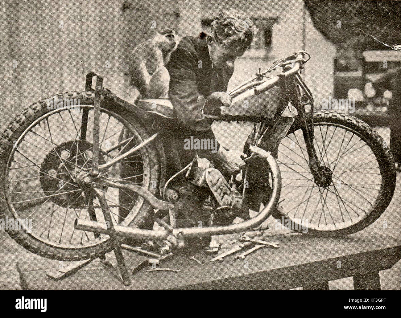 1932 Dirt track racing UK - Stripping down a  Japanese motor bike with a monkey sitting on the rider's seat Stock Photo