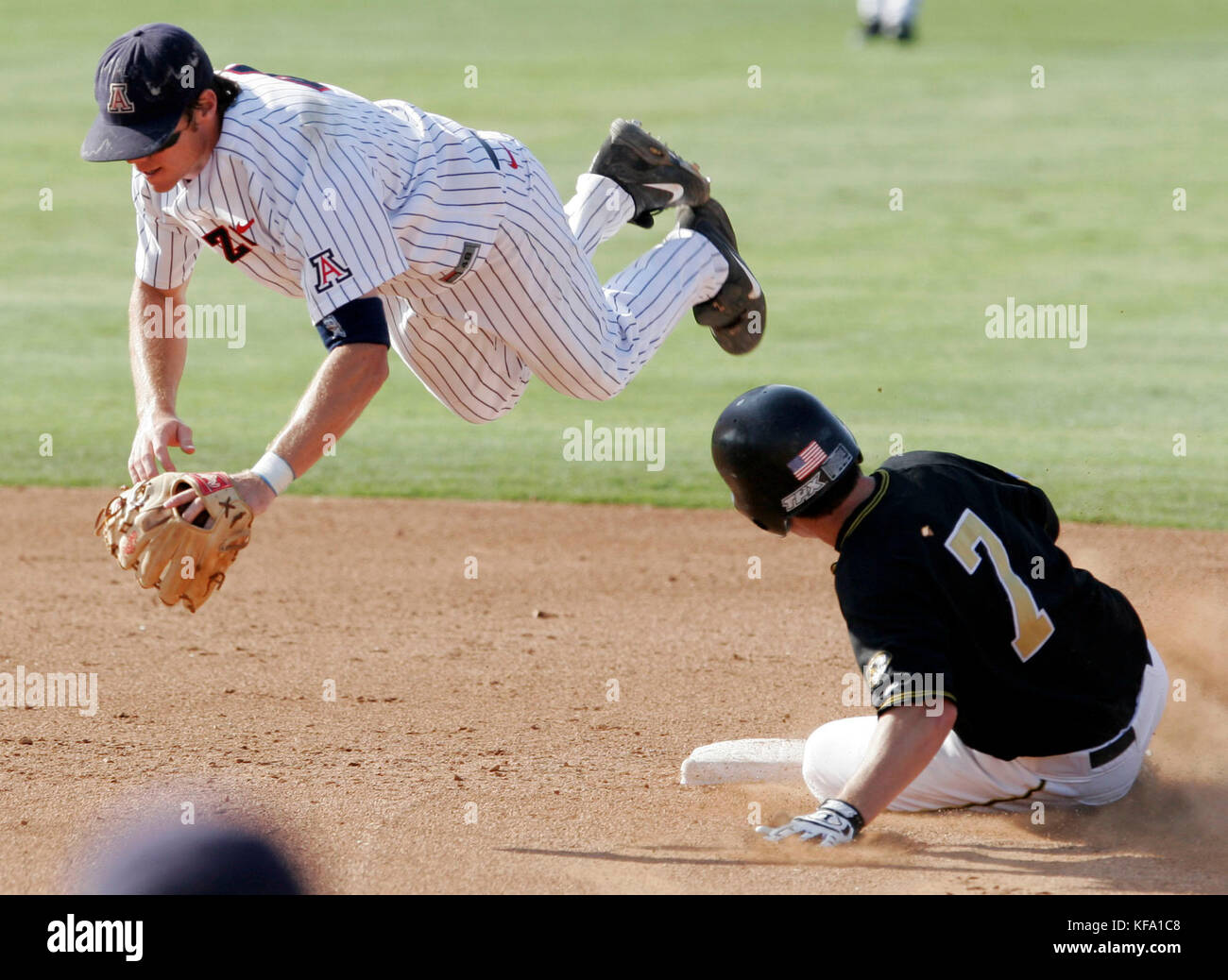 Arizona's shortstop Jason Donald, left, jumps over Missouri's Tyler Williams at second base while trying to field a errant throw by Arizona's Brad Boyer in  fifth inning at the NCAA baseball regionals play-offs in Fullerton, Calif, on Friday, June 3, 2005.  Photo by Francis Specker Stock Photo