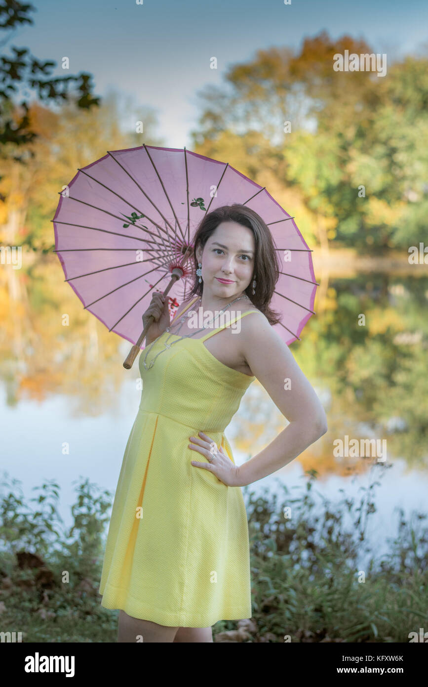 Woman with parasol in front of a creek Stock Photo