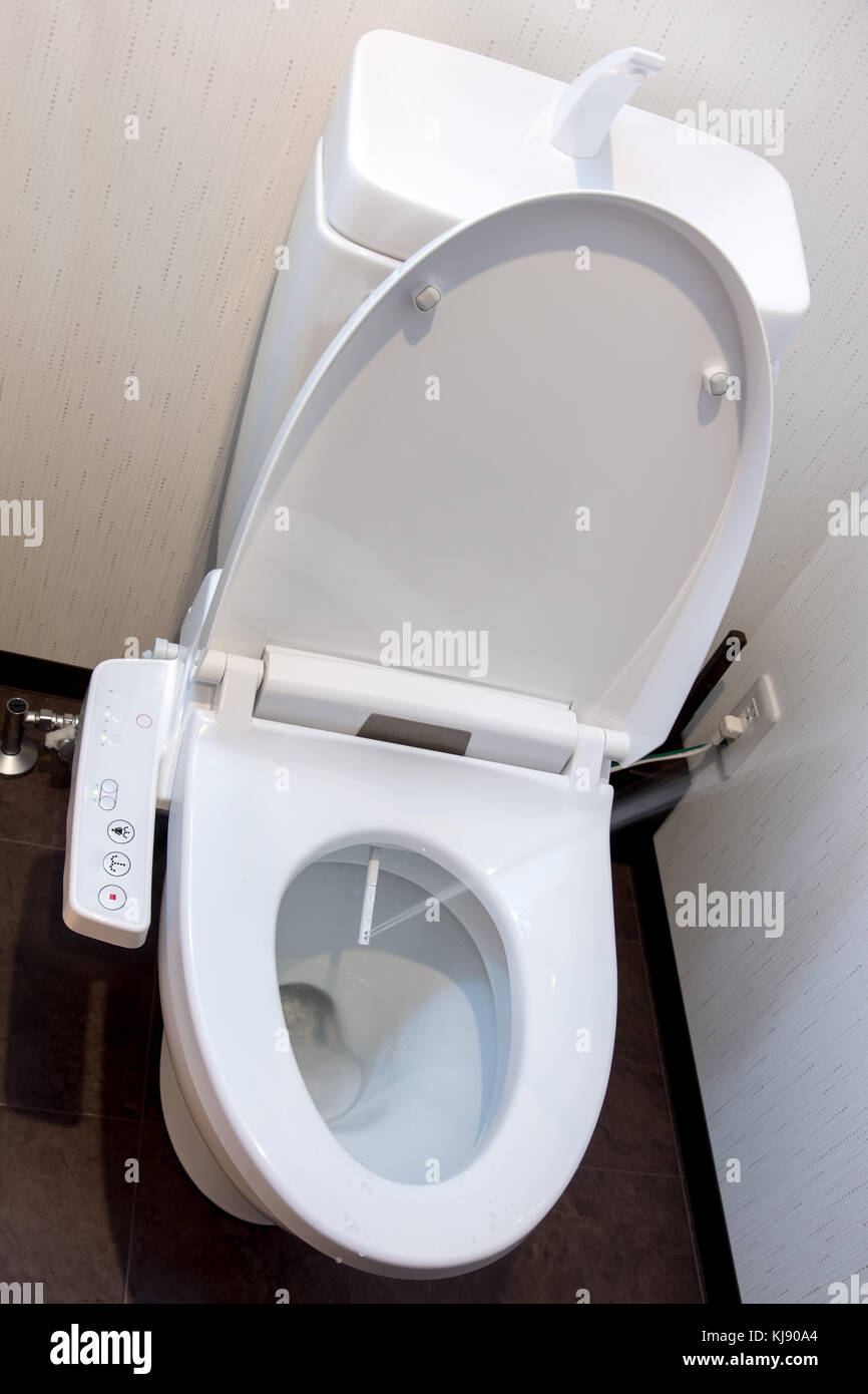 Toilet bowl with electronic control bidet. Water sprays from toilet bowl. Stock Photo