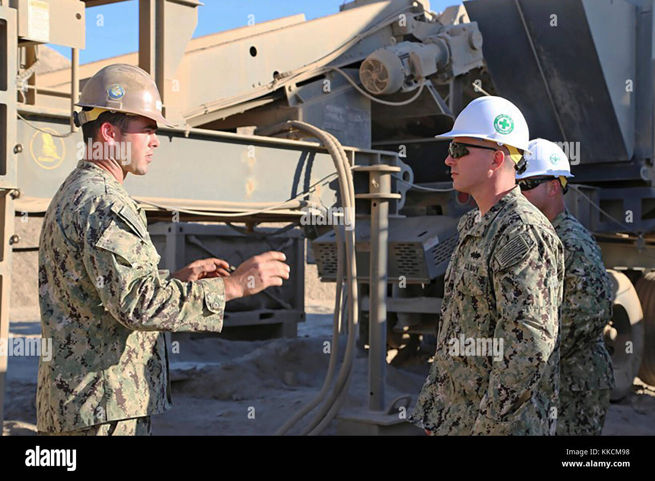 SAN CLEMENTE ISLAND, Calif. (Nov. 21, 2017) – Equipment Operator 2nd Class Tanner Wolfson (left), assigned to Naval Mobile Construction Battalion (NMCB) 4, speak with NMCB 4 Operations Officer, Lt. Cmdr.  Joseph Charles (right) on quarry and crusher plant operations. Wolfson explains the progress with material that has been crushed on the pioneer jaw and cone crusher plant and plans for future quarry operations.  San Clemente Island hosts the only active quarry operations in the Naval Construction Force where Seabees can train and take this capability forward during Major Stock Photo