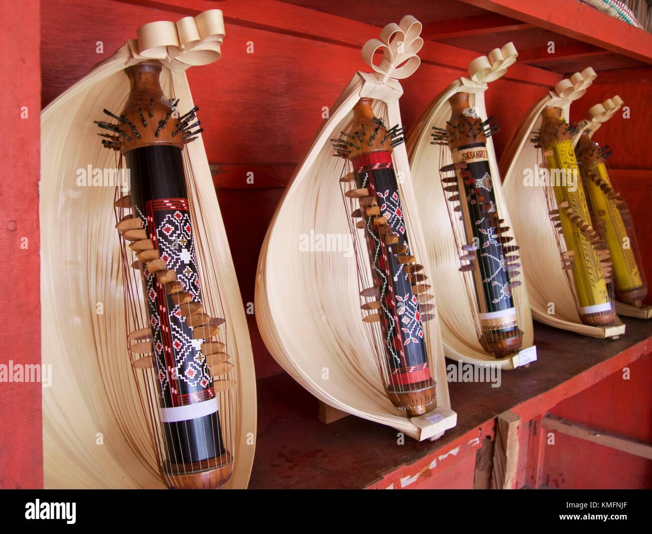 Close up of row of 'sasandu' (sasando) on display with red background, a traditional hand-made stringed musical instrument from West Timor Indonesia Stock Photo