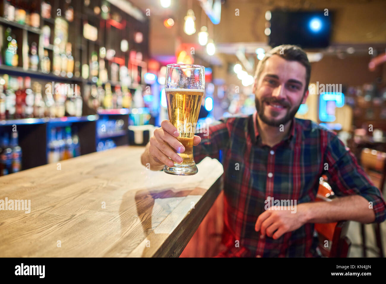 Happy Young Man Cheering at Bar Counter Stock Photo