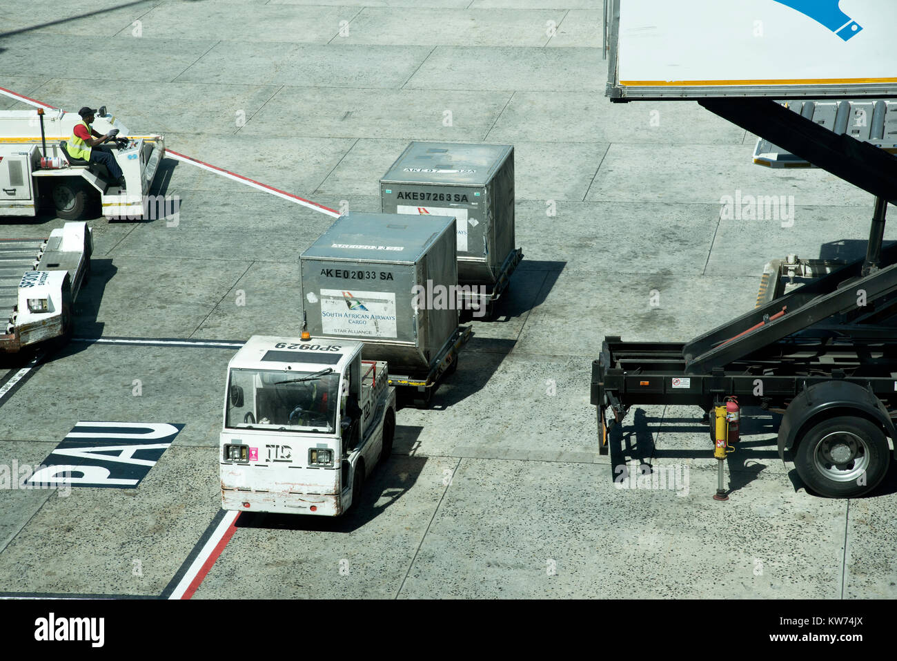 Cargo boxes being towed across the apron at Cape Town International Airport South Africa. December 2017 Stock Photo