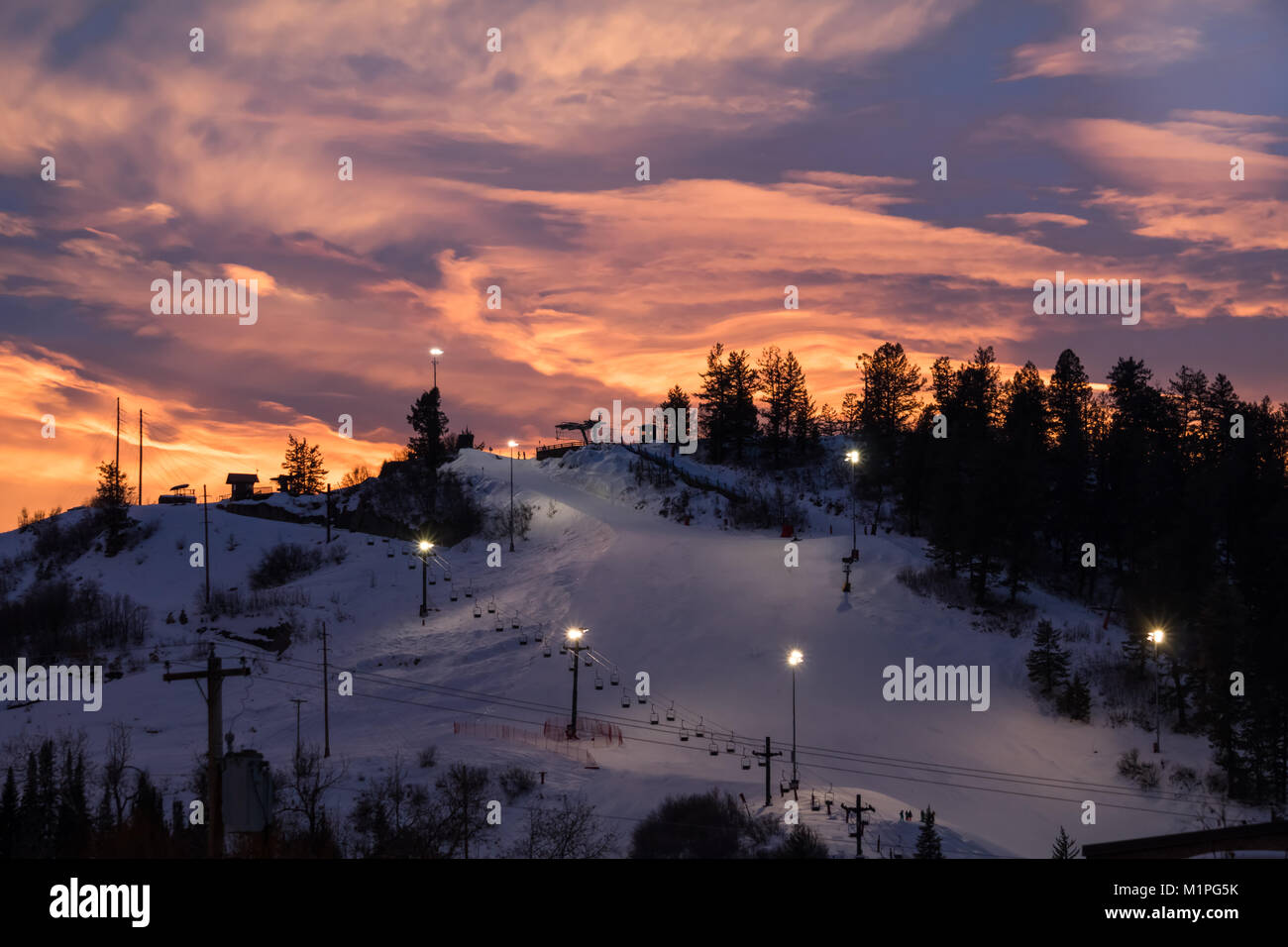 Beautiful view of a ski slope lit for night skiing in Steamboat Springs, Colorado, sunset in the mountains Stock Photo