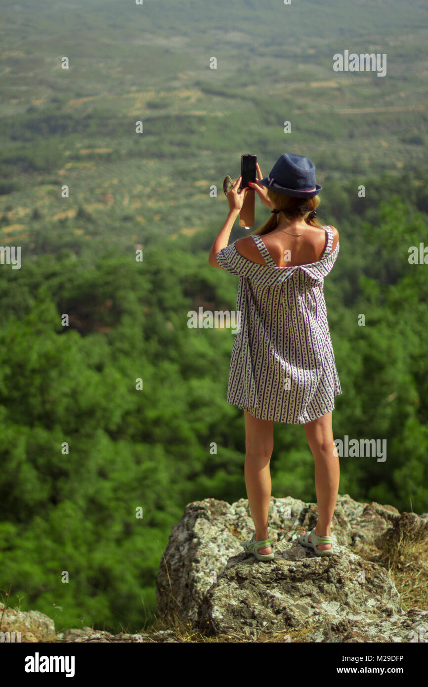 Caucasian woman in a dress photographing mountains Stock Photo