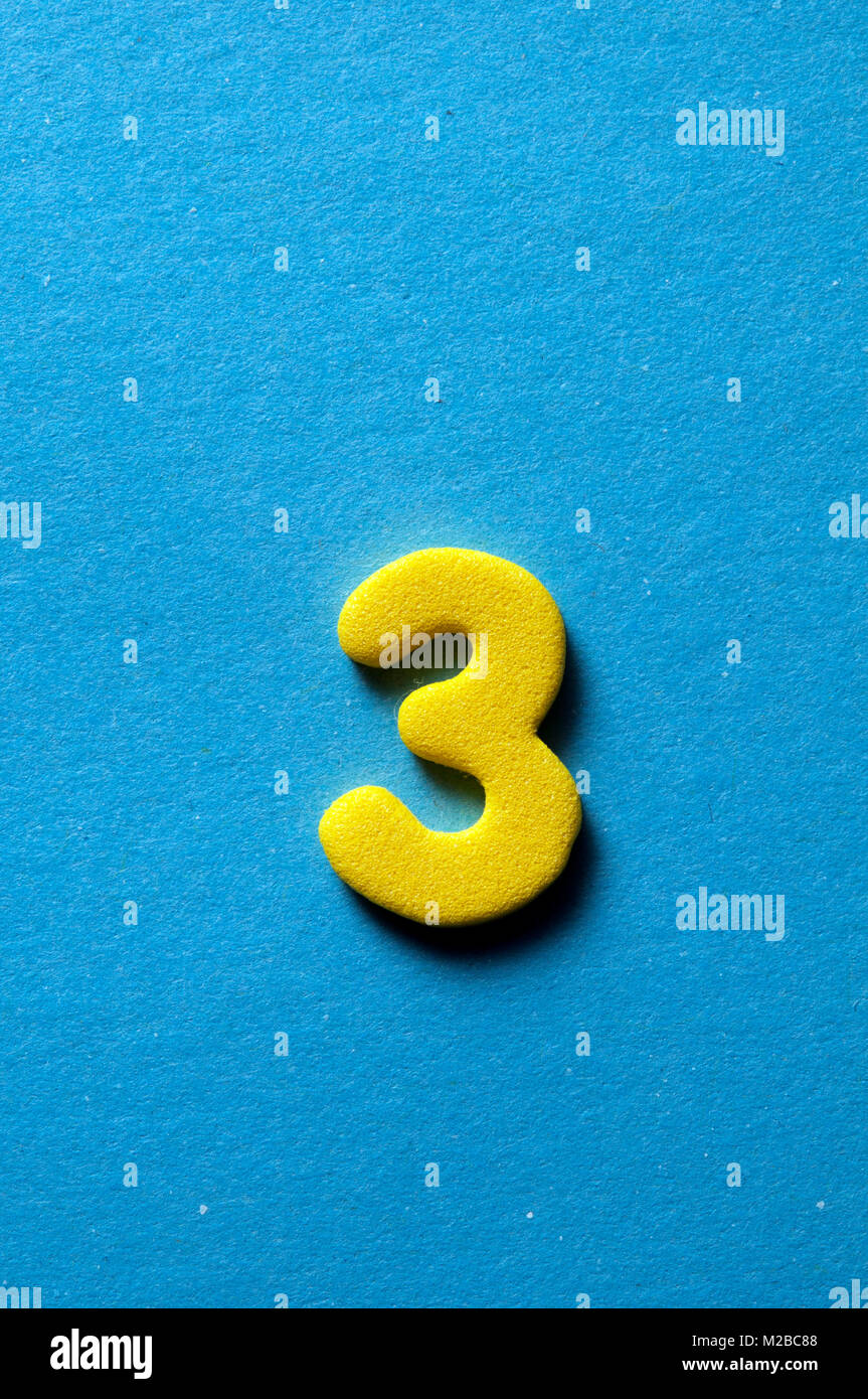 yellow number three on blue background Stock Photo