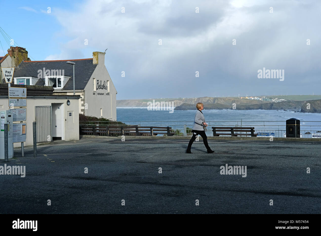 A woman walking across an empty carpark Stock Photo