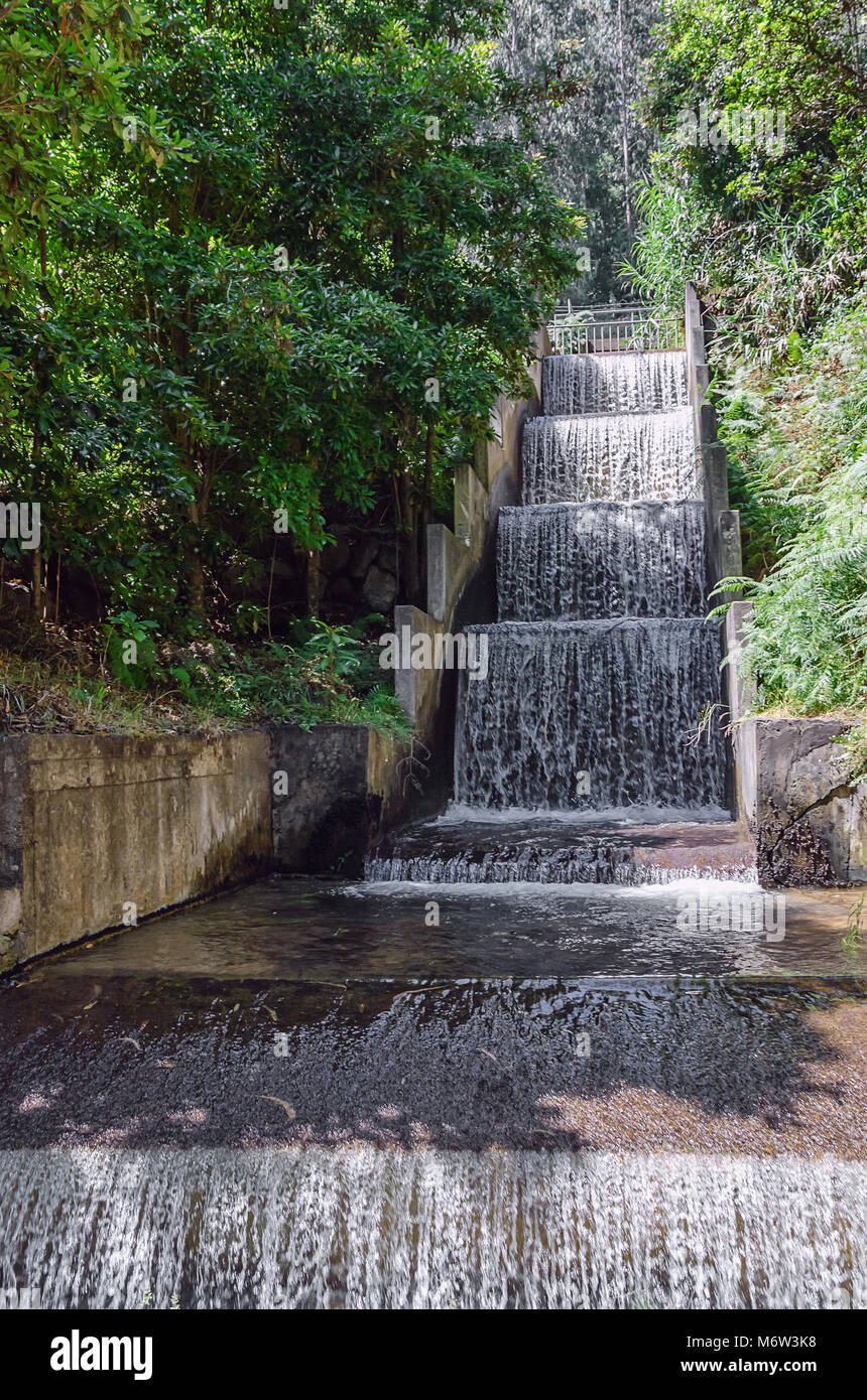 Man made waterfall with clean water running down the cascade concrete structure. Part of ecology friendly irrigation system of Madeira island, Portuga Stock Photo