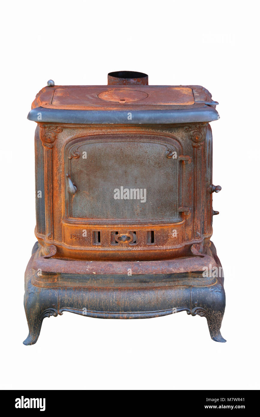 A Old rusty cast iron stove next to a barn Stock Photo