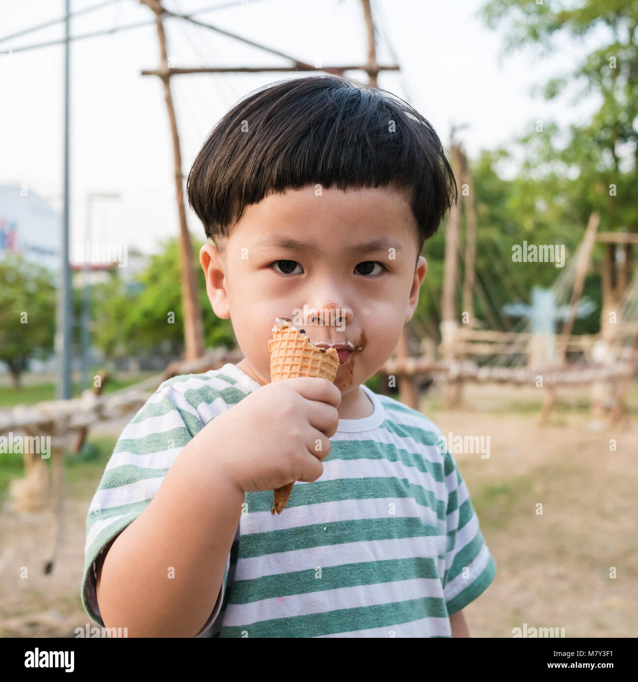 happy kid boy eating ice cream in the park Stock Photo