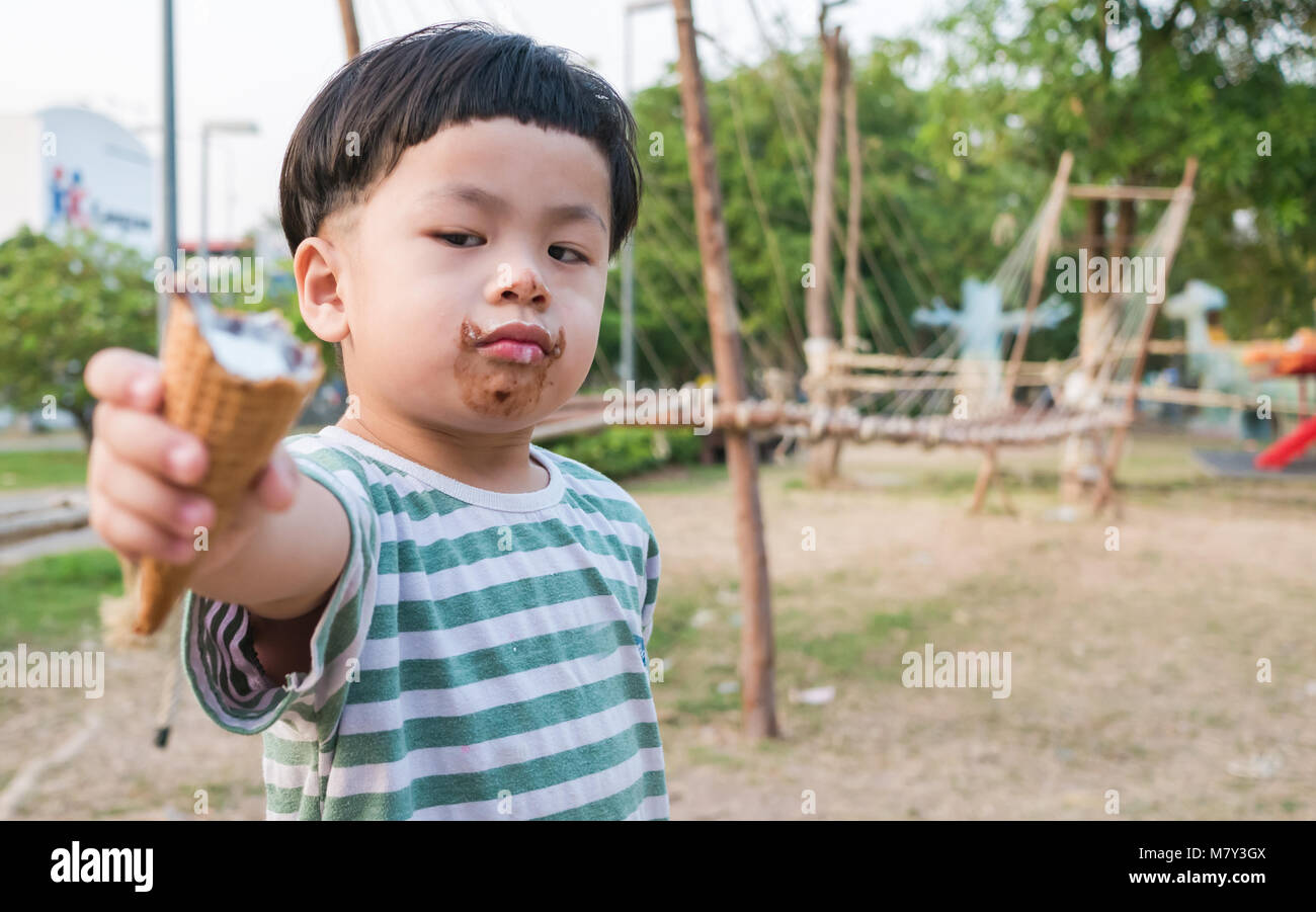 Baby handed ice cream to be morose, focus to face object, Stock Photo