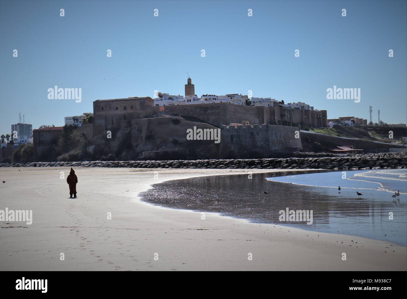 A Man Dressed in a Djellaba enjoys the Sights and Sounds at Sale Beach Stock Photo