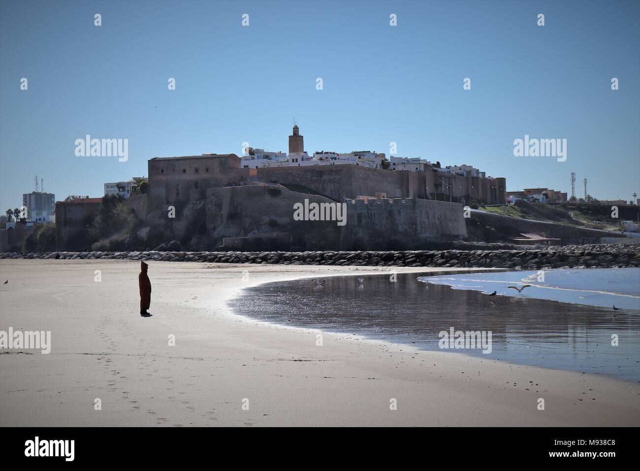 A Man Dressed in a Djellaba enjoys the Sights and Sounds at Sale Beach Stock Photo