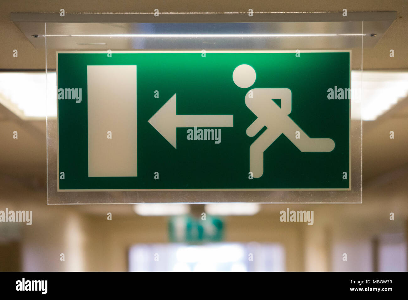 Emergency exit / fire escape sign of an illuminated type, for use in darker spaces. UK (95) Stock Photo